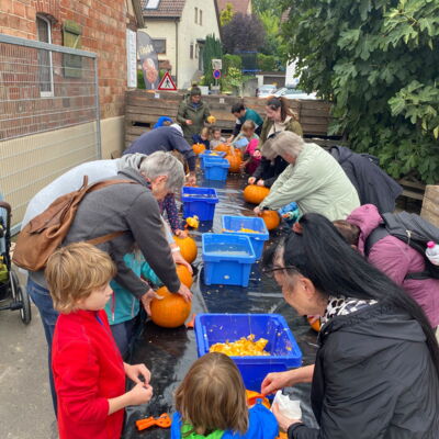 Eltern und Kinder beim Kürbis-Ausnehmen